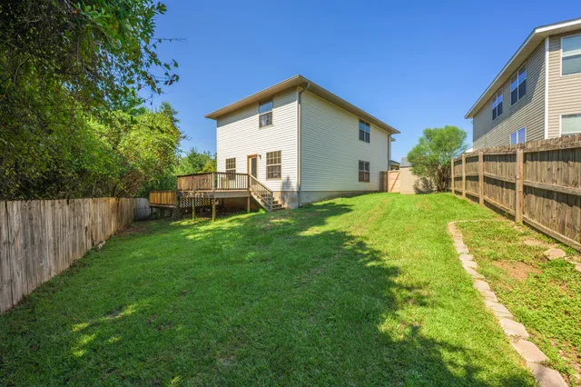 a view of a house with backyard and trees