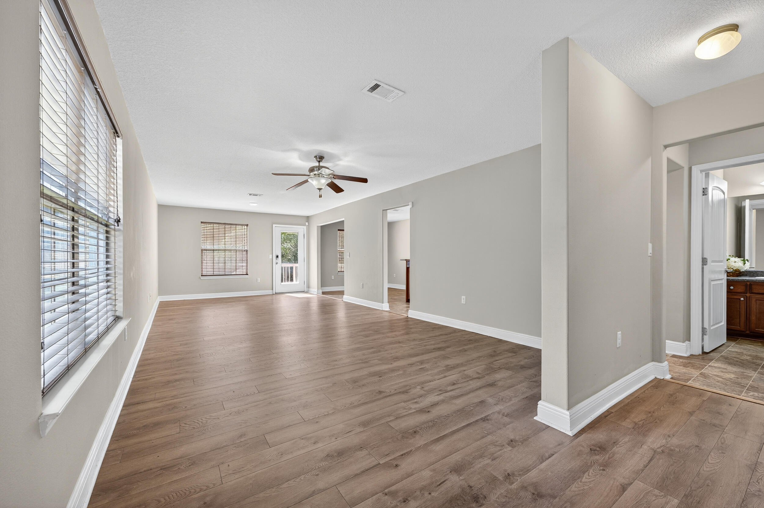 313 Gauntlet Drive Crestview, FL 32539 - Photo 7 of 44 a view of an empty room with window and wooden floor