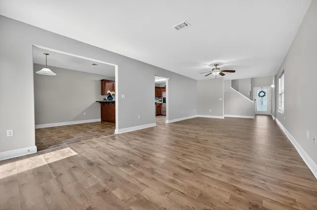 a view of a livingroom with wooden floor and staircase