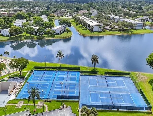 a view of a swimming pool with a yard and plants