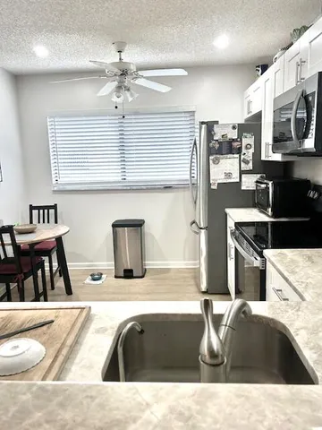 a kitchen with stainless steel appliances kitchen island granite countertop a sink and cabinets