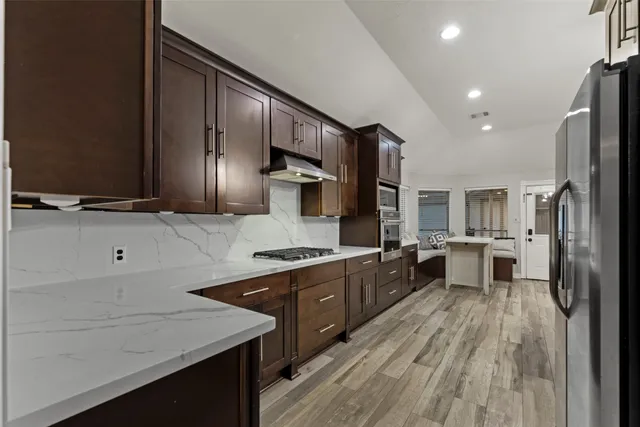 a kitchen with stainless steel appliances sink stove refrigerator and cabinets