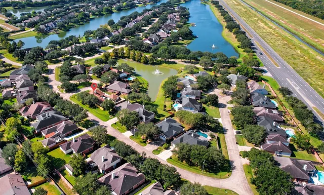 an aerial view of residential houses with outdoor space and trees