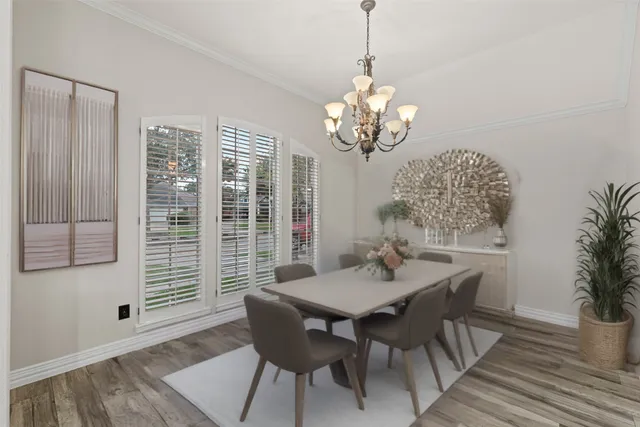 a view of a dining room with furniture wooden floor and chandelier