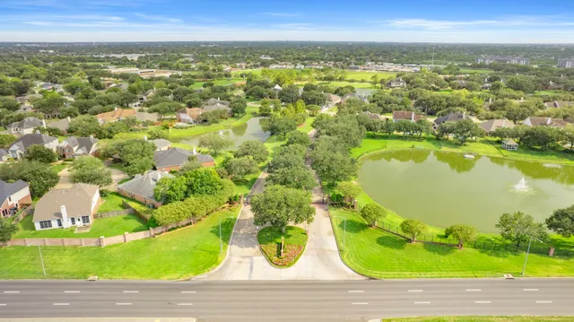 an aerial view of a house with a yard and lake view