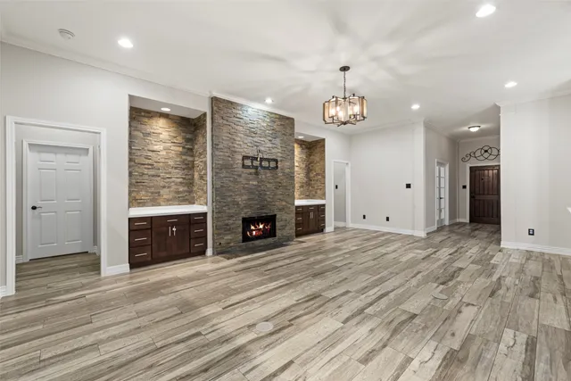 an empty room with fireplace cabinet and windows