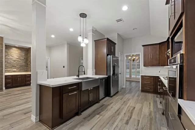 a kitchen with stainless steel appliances a sink stove and wooden floor