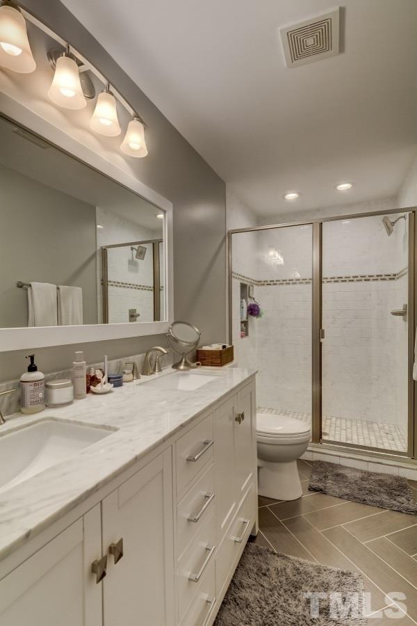3005 Old Orchard Road Raleigh, NC 27607 - Photo 12 of 21 a bathroom with a double vanity sink toilet and mirror