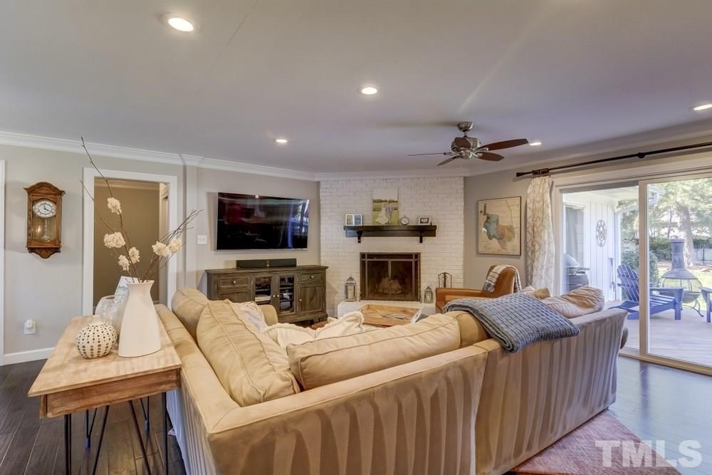 3005 Old Orchard Road Raleigh, NC 27607 - Photo 5 of 21 a living room with furniture a flat screen tv and a fireplace