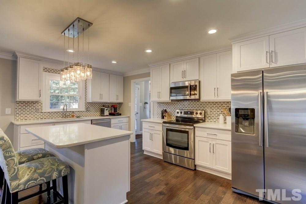 3005 Old Orchard Road Raleigh, NC 27607 - Photo 7 of 21 a kitchen with kitchen island granite countertop stainless steel appliances cabinets a sink and a center island