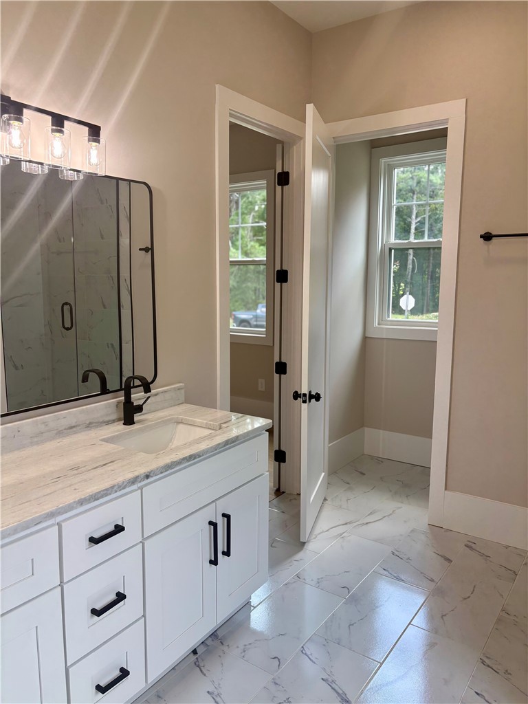 854 Perkins Creek Road Seneca, SC 29678 - Photo 15 of 34 Polished tile flooring and marble counters elevate this modern secondary bathroom.