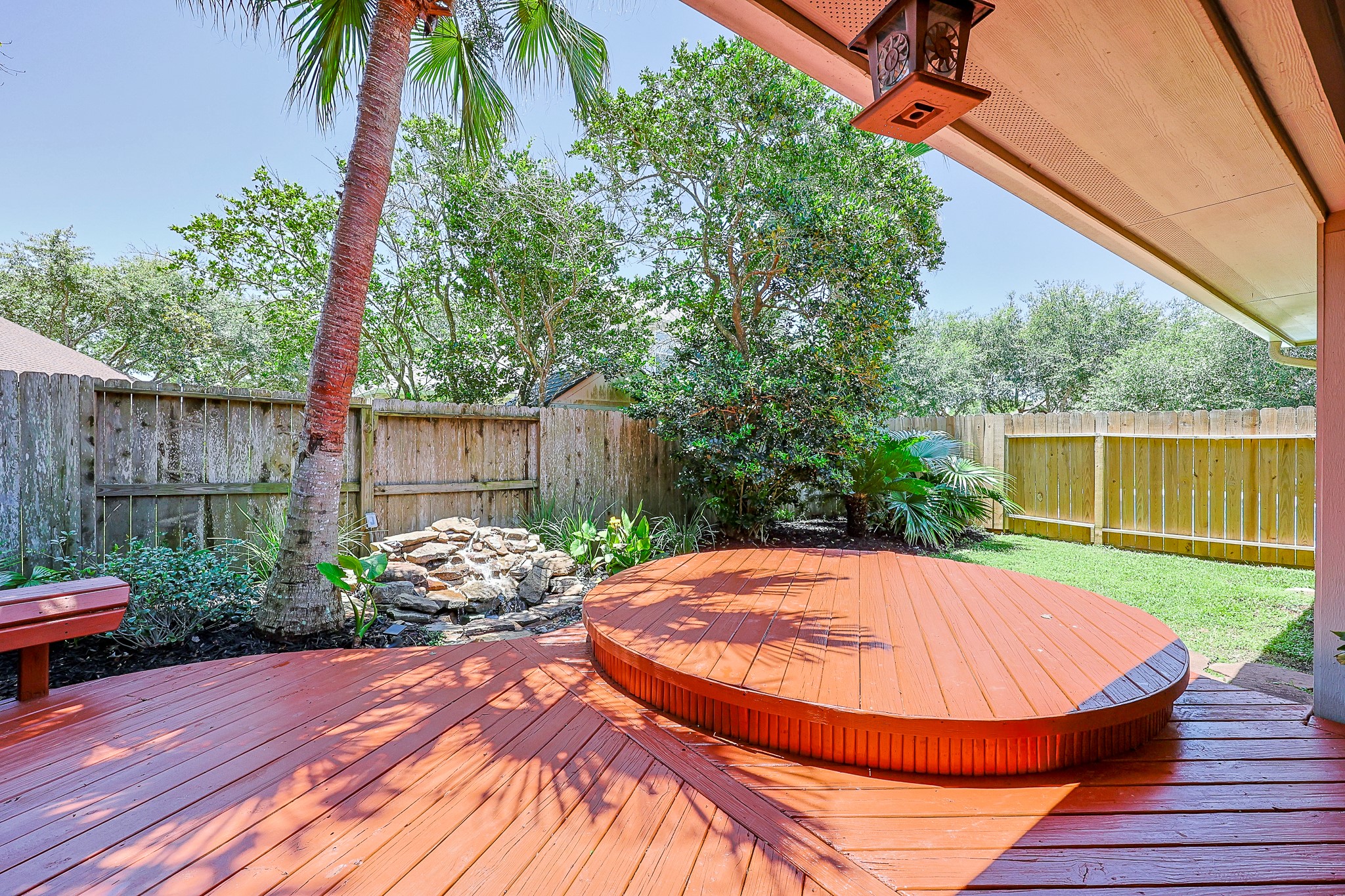 10306 Rudolph Court Missouri City, TX 77459 - Photo 26 of 34 Key highlights showcases beautifully stained, rich-toned wood deck that offers multiple zones for lounging and outdoor dining. Custom-crafted, curved wooden bench built directly into the deck profile for effortless guest seating.