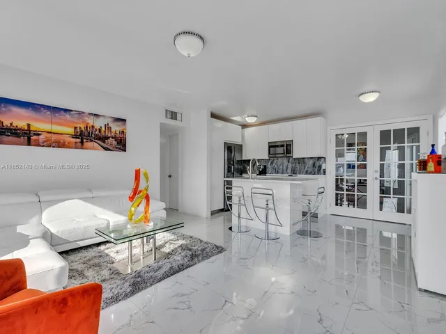 a living room with furniture and view of kitchen