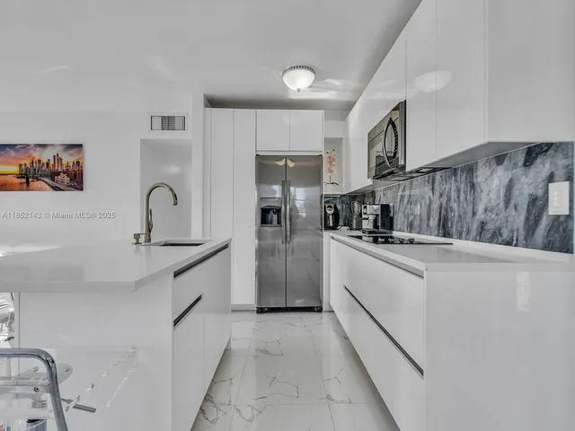 a kitchen with granite countertop a refrigerator and a sink