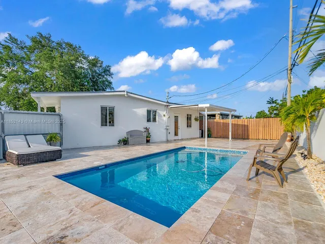 a view of a house with backyard and sitting area