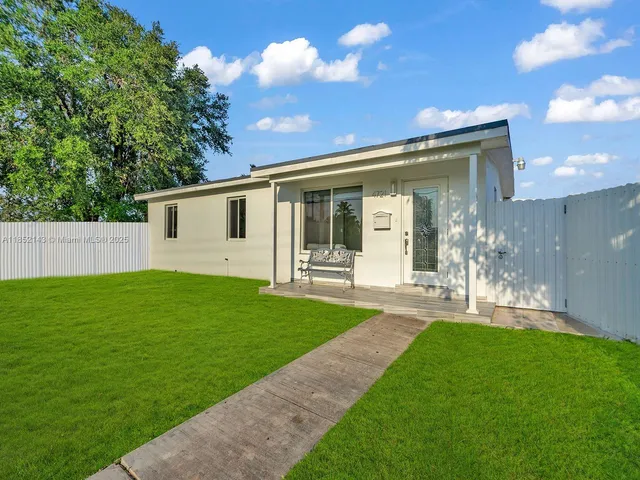 a front view of a house with a garden and yard