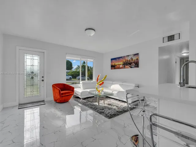a living room with furniture a large window and a chandelier