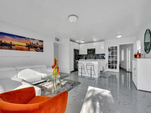 a living room with furniture and kitchen view