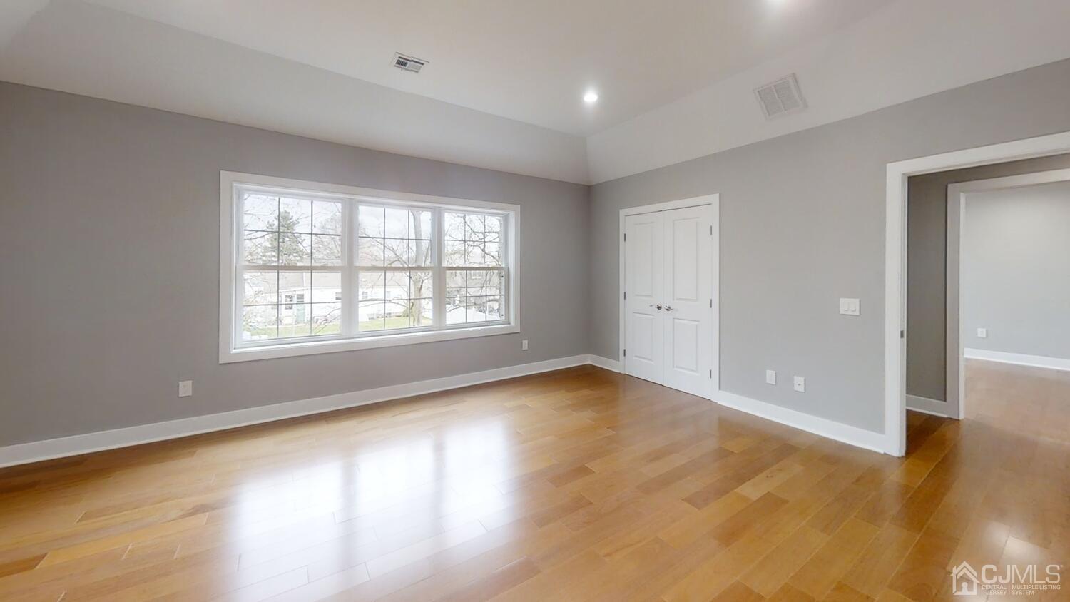 26 Highfield Road Colonia, NJ 07067 - Photo 16 of 30 an empty room with wooden floor and windows with curtains