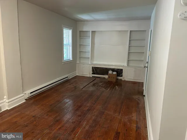 a view of a room with wooden floor and a window