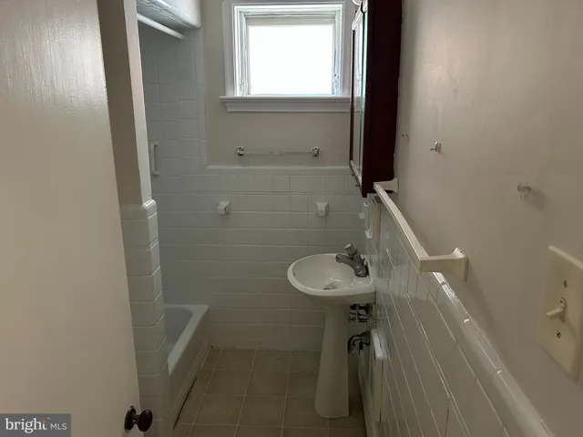a bathroom with a sink a window and shower