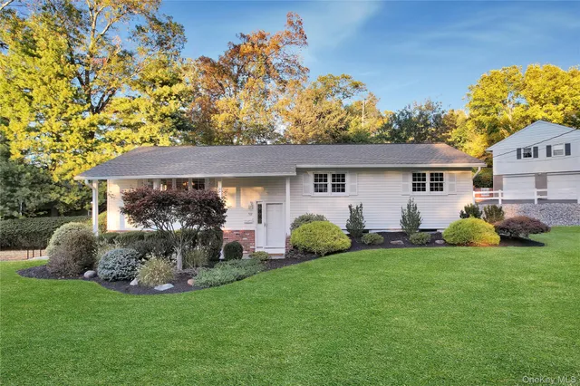 a front view of a house with a garden and yard
