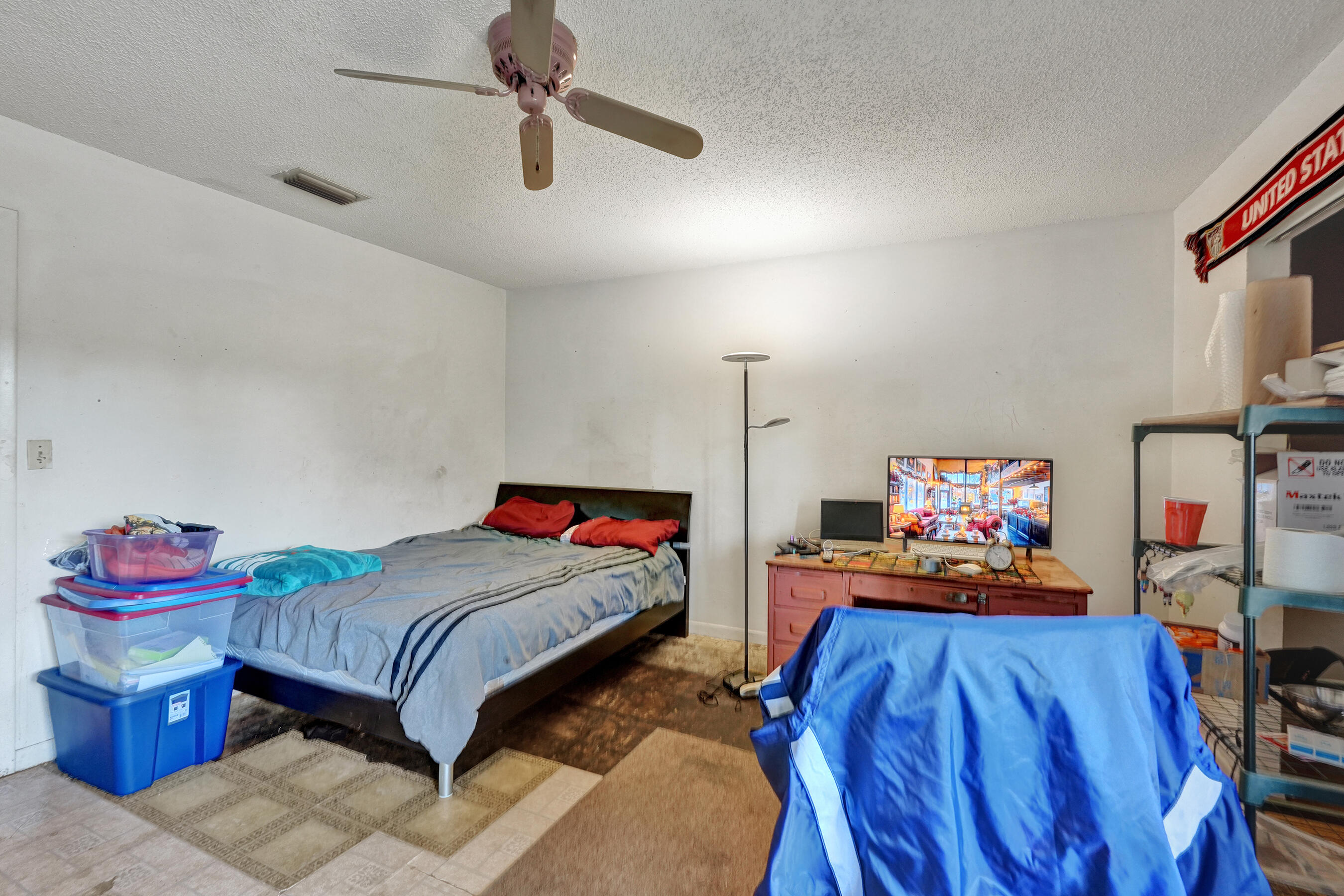 6505 Dockside Circle Greenacres, FL 33463 - Photo 31 of 38 a bedroom with a bed a dresser and flat screen tv