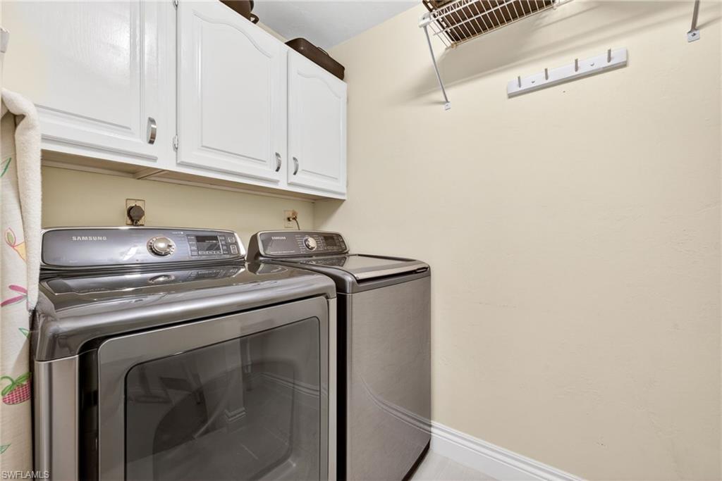 4030 Crayton Road, Unit C2 Naples, FL 34103 - Photo 29 of 32 a view of washer and dryer with kitchen in the background