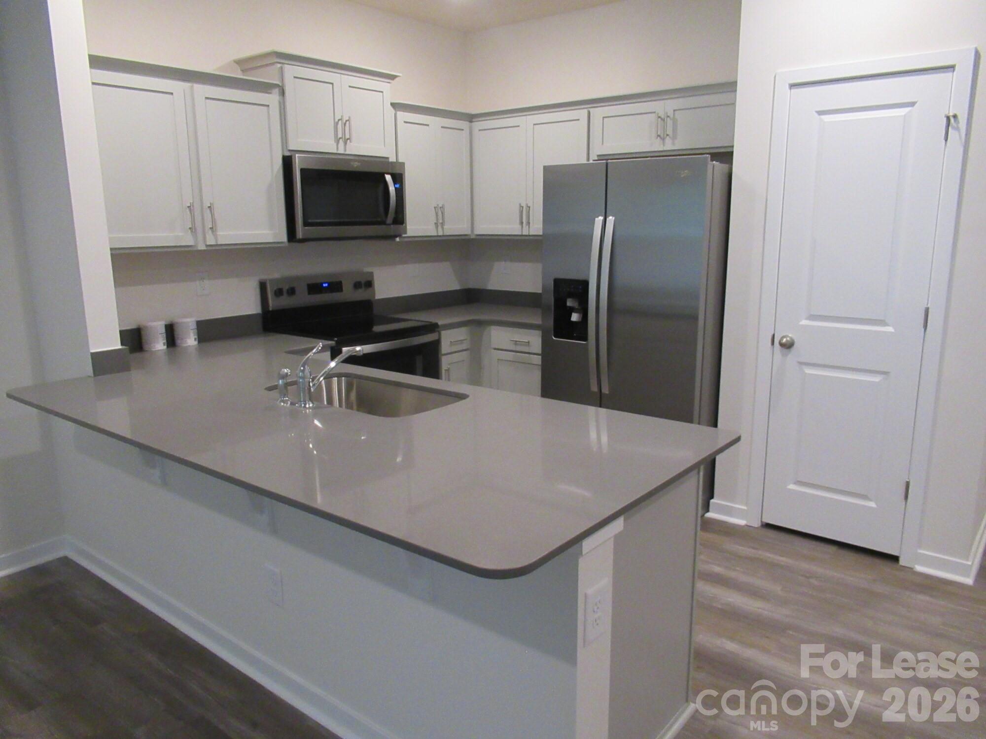 3192 Ora Smith Road Lincolnton, NC 28092 - Photo 8 of 34 a kitchen with stainless steel appliances a microwave a sink and a refrigerator