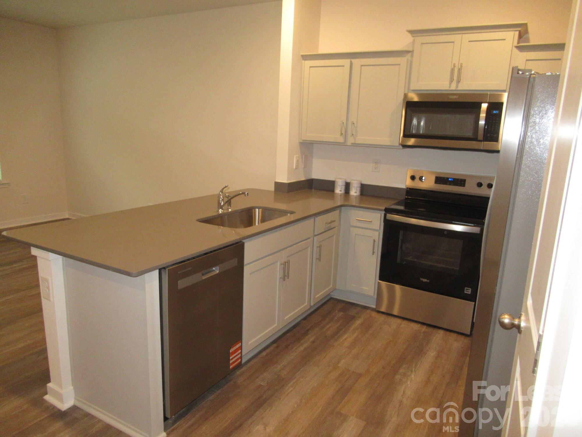 3192 Ora Smith Road Lincolnton, NC 28092 - Photo 9 of 34 a kitchen with stainless steel appliances granite countertop a stove a microwave and a sink