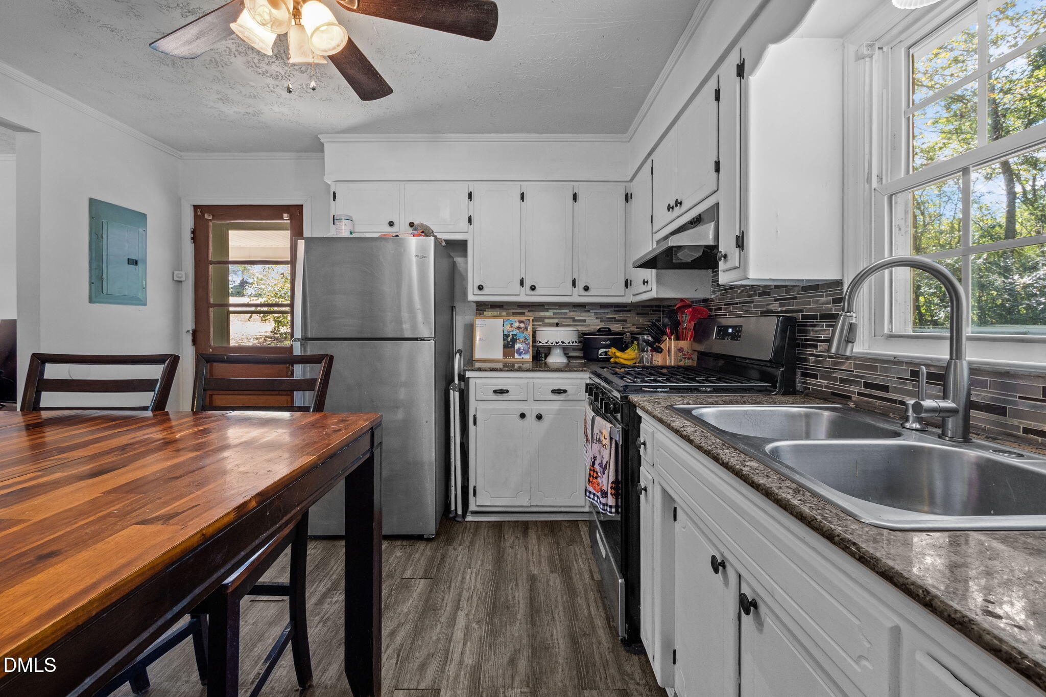 670 Tingen Mine Road Roxboro, NC 27574 - Photo 8 of 30 a kitchen with a refrigerator a sink dishwasher a stove and a dining table with wooden floor