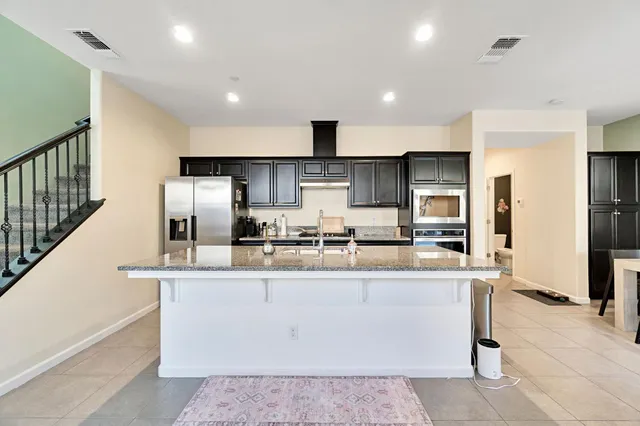 a large kitchen with stainless steel appliances lots of counter top space cabinets and a center island