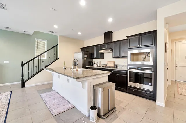 a kitchen with stainless steel appliances granite countertop a stove a sink and a refrigerator