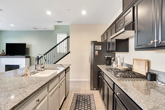 a kitchen with stainless steel appliances granite countertop a sink stove and refrigerator