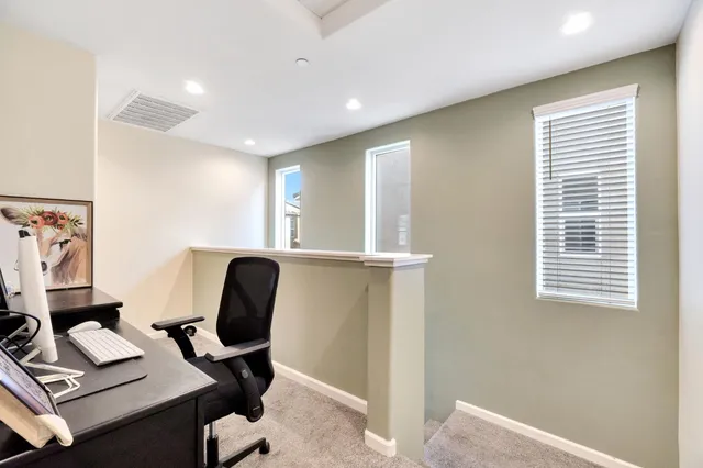 a view of a workspace with furniture and a window