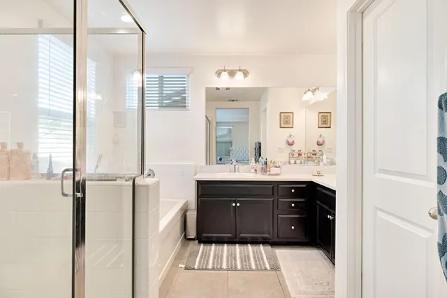 a bathroom with a sink vanity granite tub and shower