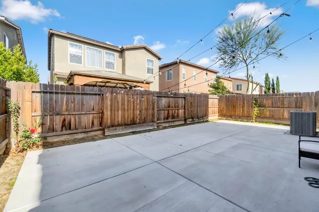 a view of a house with a small yard and wooden fence