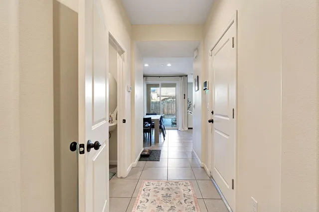 a view of a hallway with dining area and glass doors