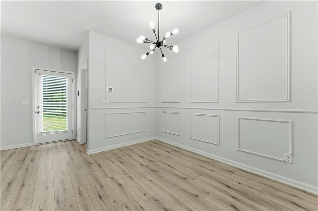 7492 Knoll Hollow Road Lithonia, GA 30058 - Photo 10 of 30 an empty room with wooden floor closet and windows