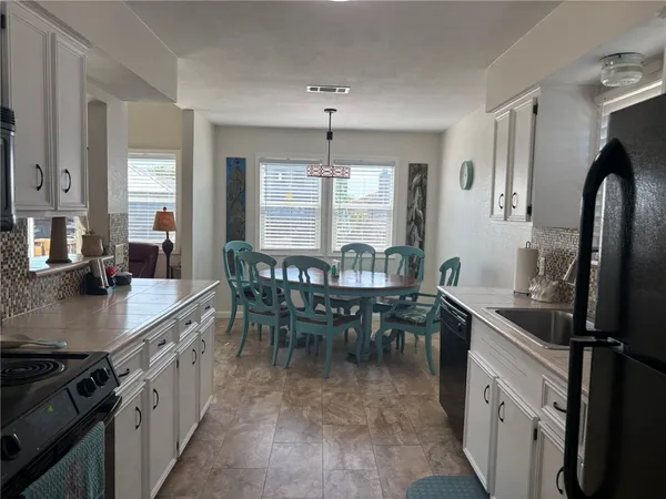 a kitchen with kitchen island granite countertop a sink stove and table