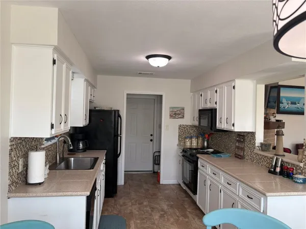a kitchen with a sink a stove and a refrigerator