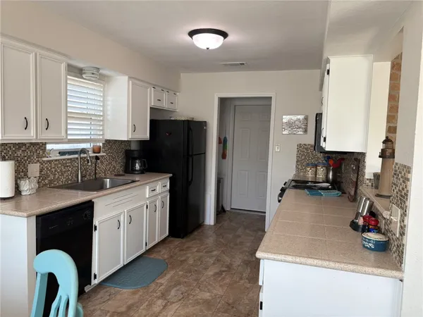 a kitchen with a sink a refrigerator and a stove