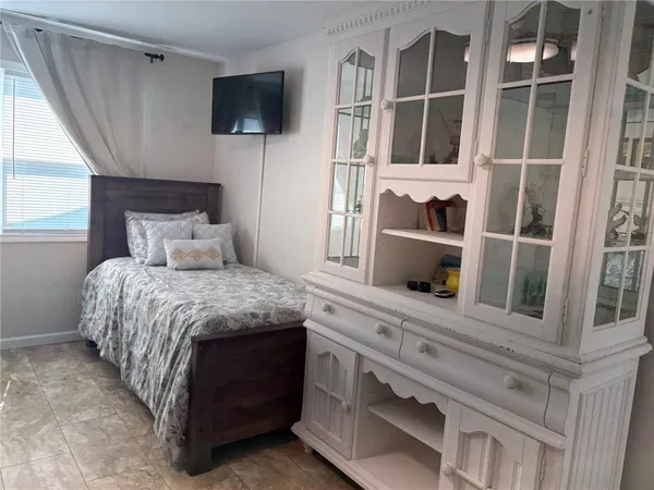 a bedroom with a bed and flat screen tv