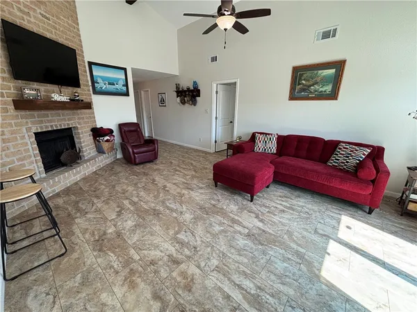 a living room with furniture a flat screen tv and a fireplace