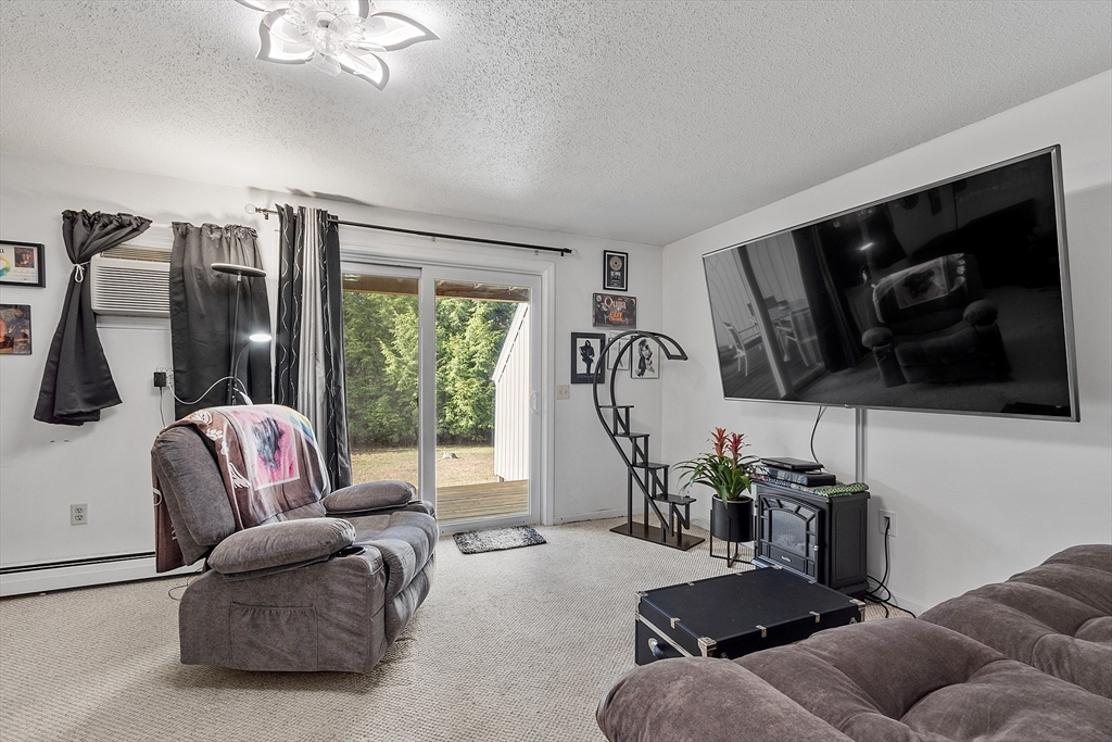 168 Ayer Road, Unit F3 Shirley, MA 01464 - Photo 12 of 36 a living room with furniture a flat screen tv and a window