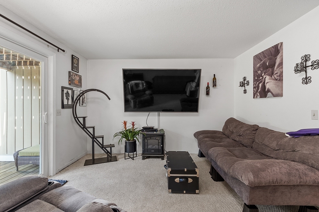 168 Ayer Road, Unit F3 Shirley, MA 01464 - Photo 13 of 36 a living room with furniture and a flat screen tv