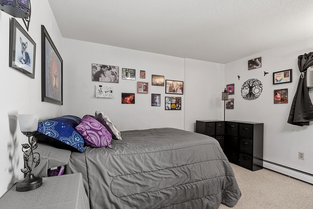 168 Ayer Road, Unit F3 Shirley, MA 01464 - Photo 15 of 36 a bedroom with a bed and painting on the wall