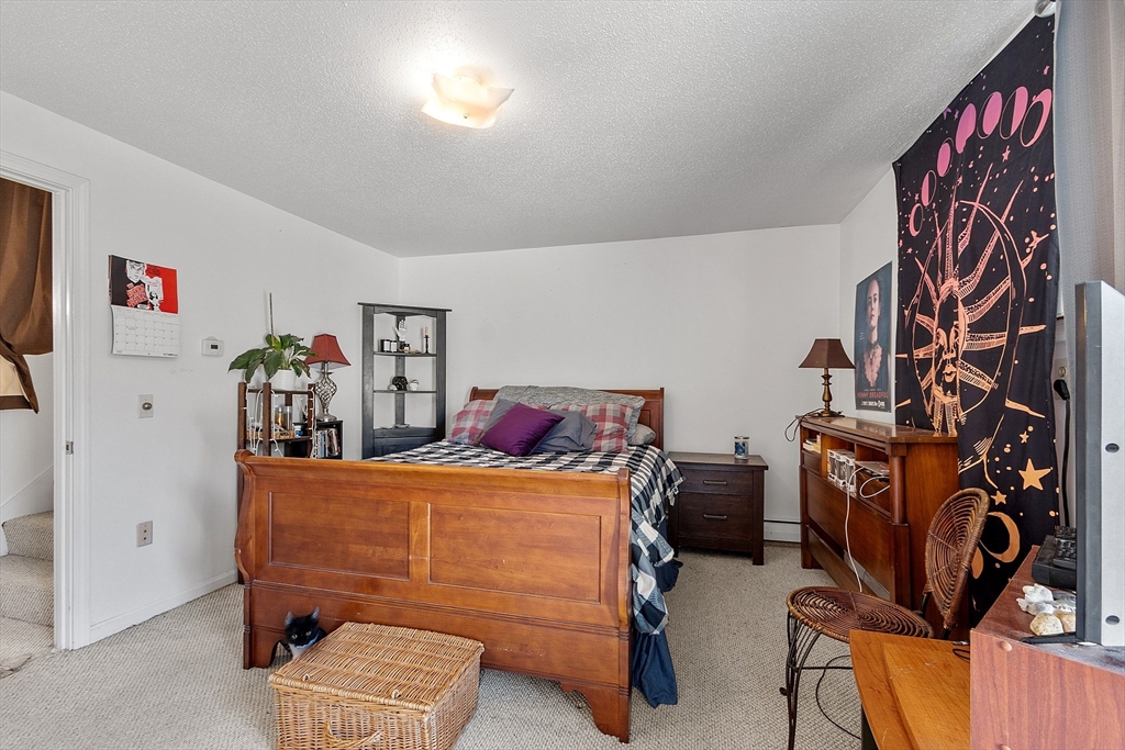 168 Ayer Road, Unit F3 Shirley, MA 01464 - Photo 18 of 36 a bedroom with a bed and wooden floor