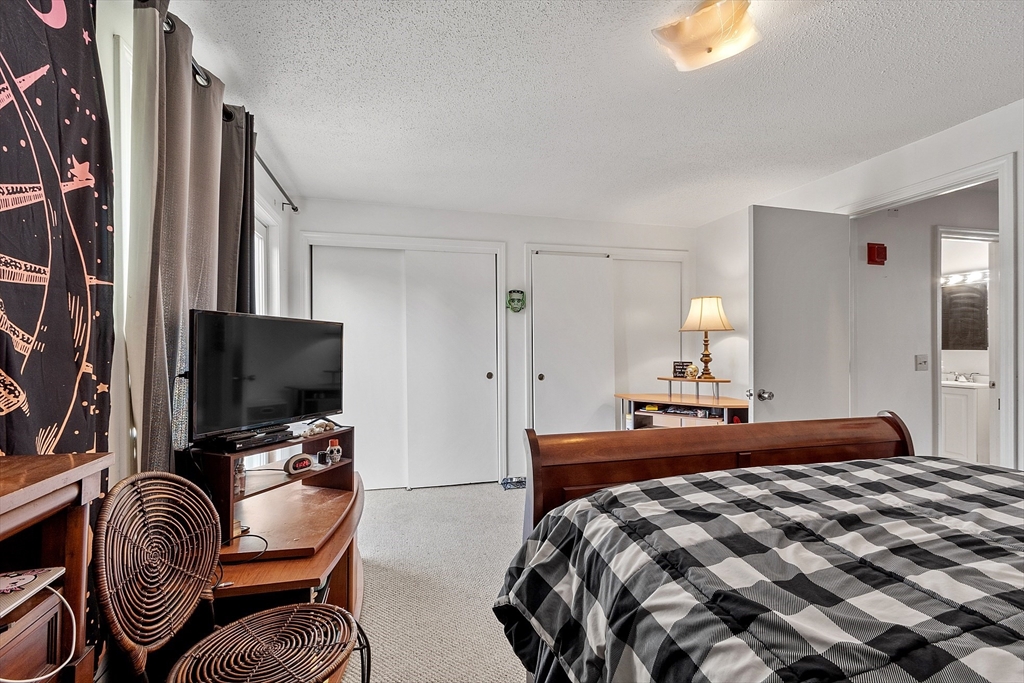 168 Ayer Road, Unit F3 Shirley, MA 01464 - Photo 19 of 36 a bedroom with a bed and a flat screen tv
