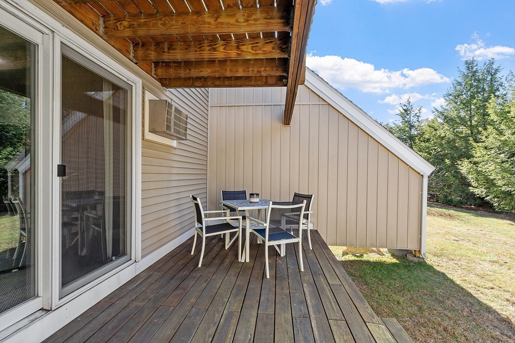 168 Ayer Road, Unit F3 Shirley, MA 01464 - Photo 27 of 36 a roof deck with a table and chairs and wooden floor